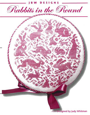 Cross-stitch pattern 'Rabbits in the Round' by JBW Designs in pink tones, featuring playful rabbit motifs.