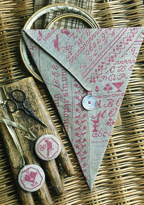Handmade linen sewing pouch with pink embroidery, featuring scissors and accessories on a rustic background.