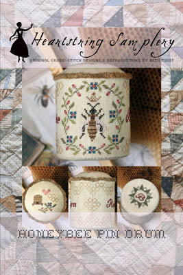 Honeybee pin drum by Heartstring Samplery featuring intricate cross-stitch designs on a decorative fabric.