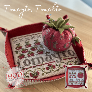 Handcrafted 'Tomayto, Tomohto' cross-stitch decor in red with tomato-shaped pin cushion on a tray.
