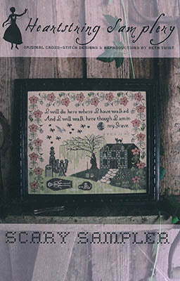 Framed cross-stitch artwork titled 'Scary Sampler' featuring a haunted house and floral designs.