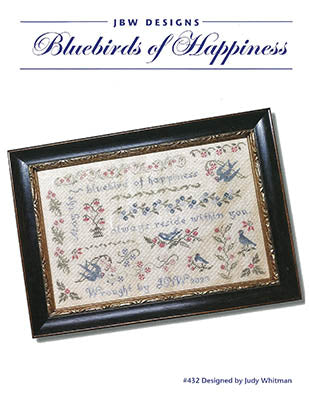 Framed cross-stitch artwork featuring bluebirds and floral designs, titled 'Bluebirds of Happiness'.