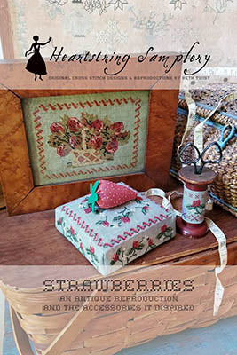 Antique-style strawberry sampler, featuring floral embroidery, vibrant colors, and vintage sewing accessories.