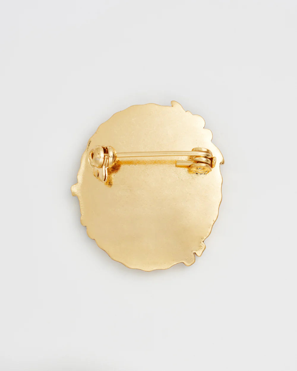 Gold brooch with a unique wavy edge design featuring a secure pin closure.