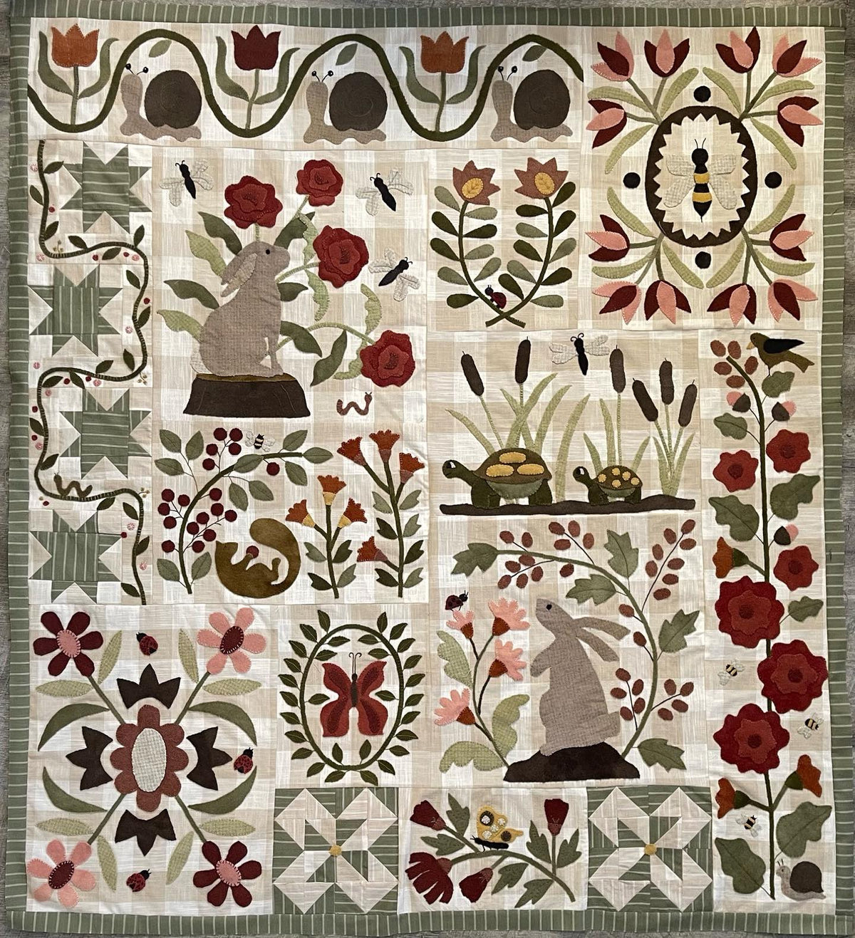 Handcrafted quilt featuring colorful floral patterns, rabbits and turtles, in earthy tones and cotton fabric.