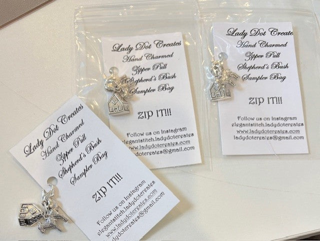 Handcrafted silver charms for zipper pulls in a sampler bag, featuring house and shepherd's bush designs.