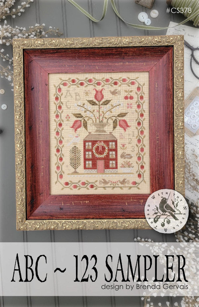Framed ABC 123 sampler cross-stitch by Brenda Gervais, featuring floral design in warm colors on linen.