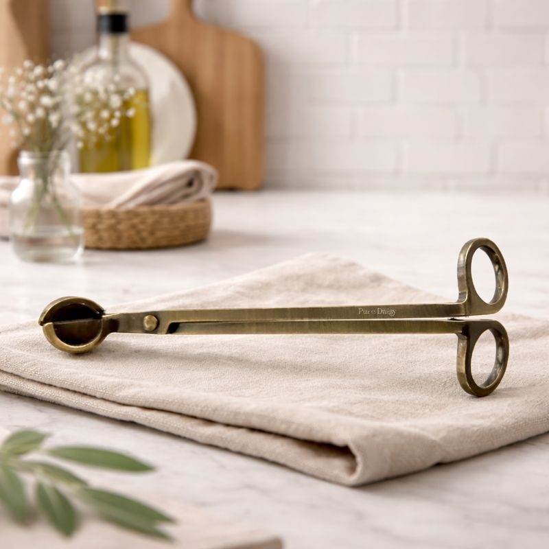 Brass candle snuffer with dual handles, stylish and functional for home decor.