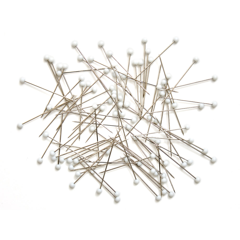Set of silver sewing pins with white round heads, perfect for fabric and crafting projects.