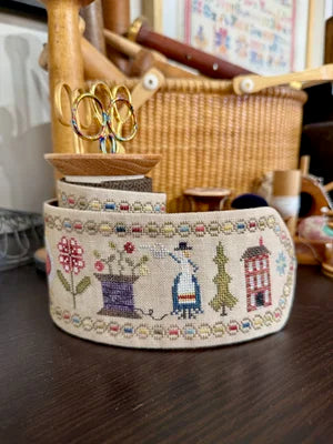 Handmade fabric ribbon featuring colorful floral and house embroidery, perfect for crafting and decor.
