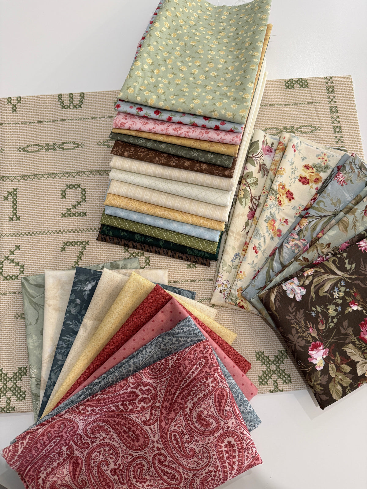 Assorted cotton fabric bundles in floral and paisley patterns, perfect for quilting and sewing projects.