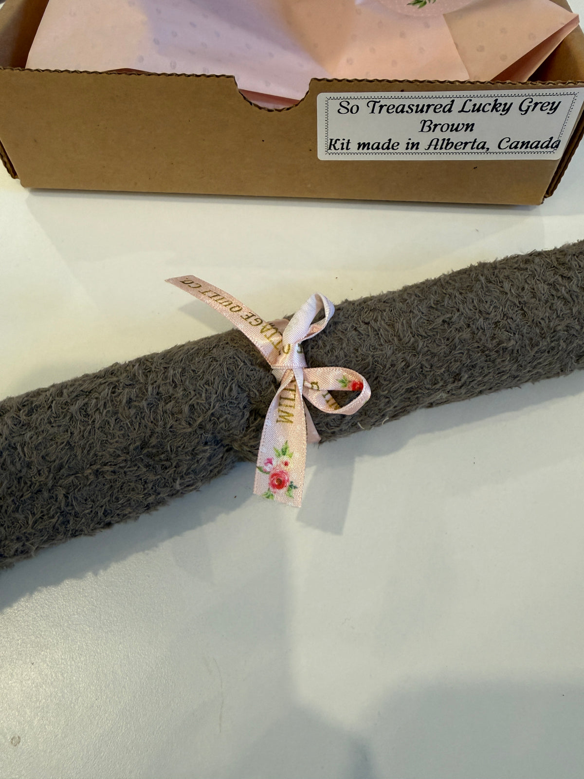 Soft grey towel roll tied with a floral ribbon, part of the So Treasured kit from Alberta, Canada.