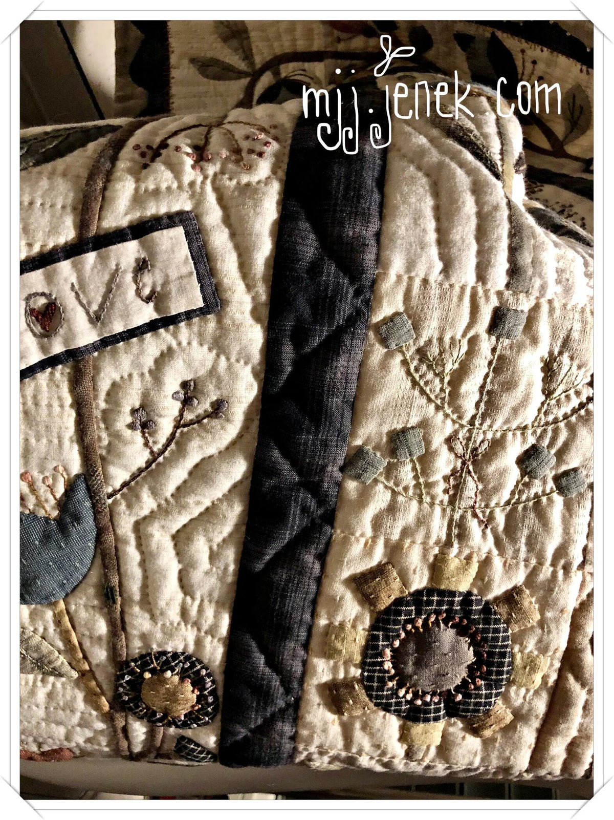 Quilted vintage-style bag in cream, featuring floral embroidery and dark blue straps.