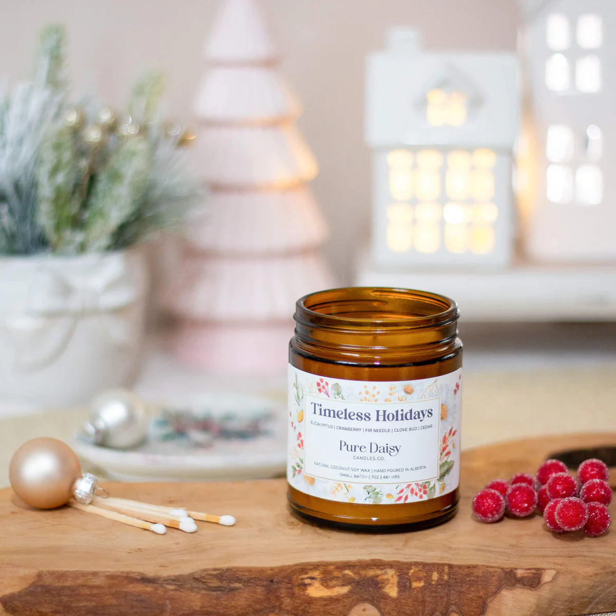 Timeless Holidays candle with eucalyptus, cranberry, and cedar scent in amber jar, made from natural coconut wax.