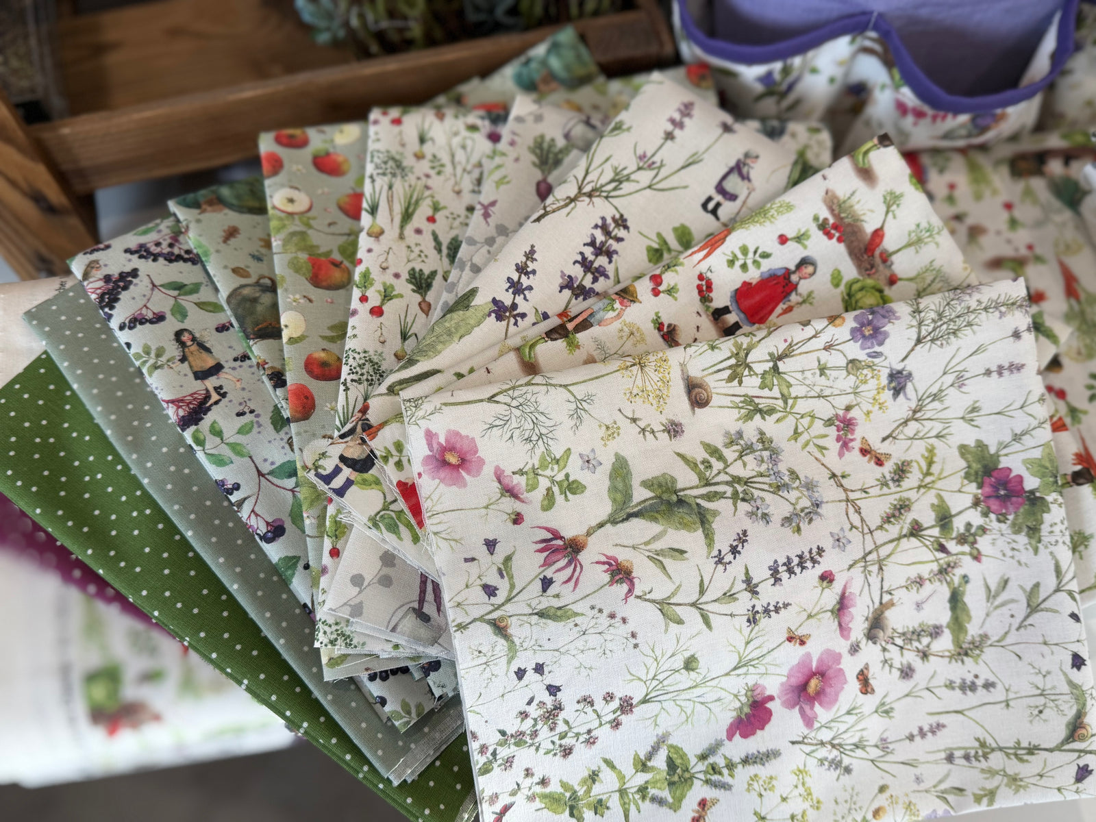Colorful fabric swatches featuring floral and whimsical patterns, perfect for sewing projects and crafts.