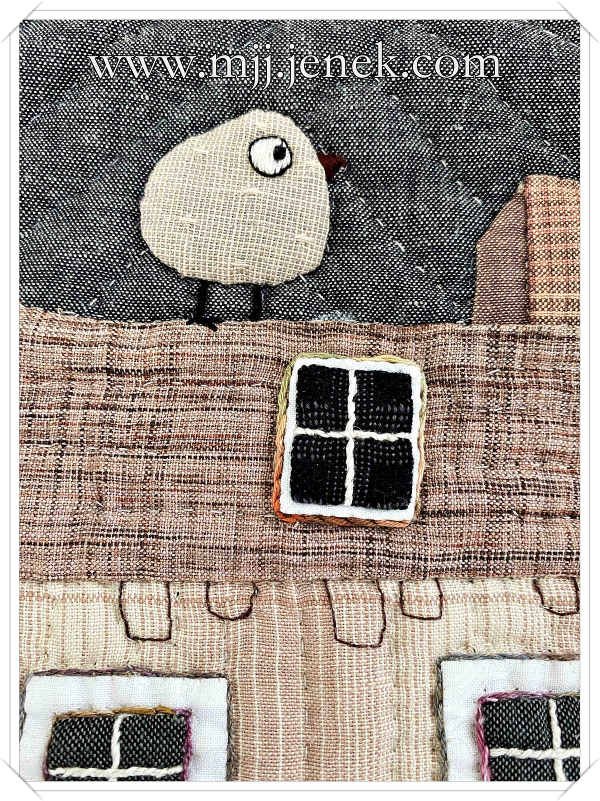 Handcrafted textile art featuring a whimsical bird on a rooftop with stitched details and muted color tones.