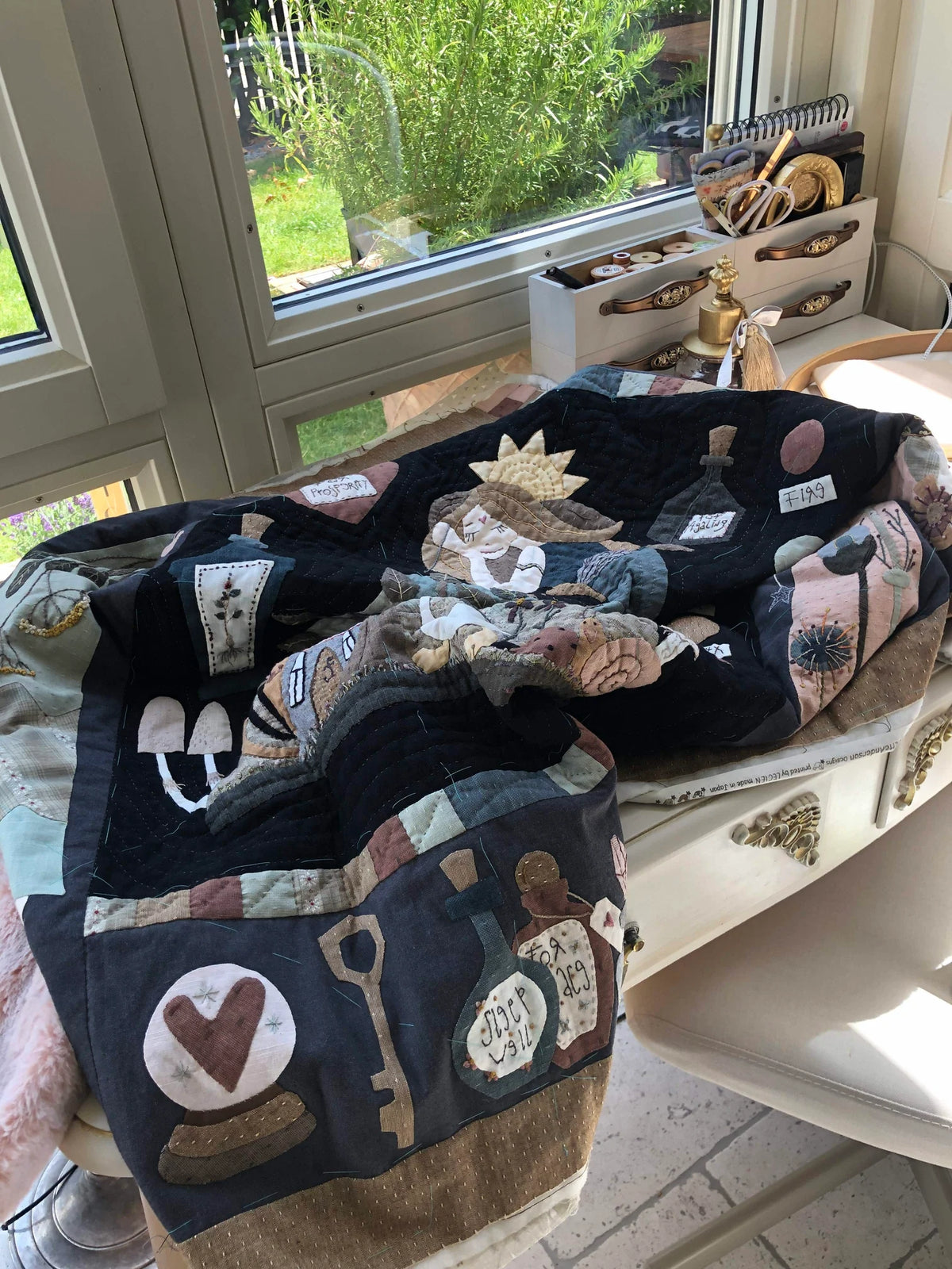 Colorful patchwork quilt featuring vintage-style appliqué designs on a black background, perfect for home decor.