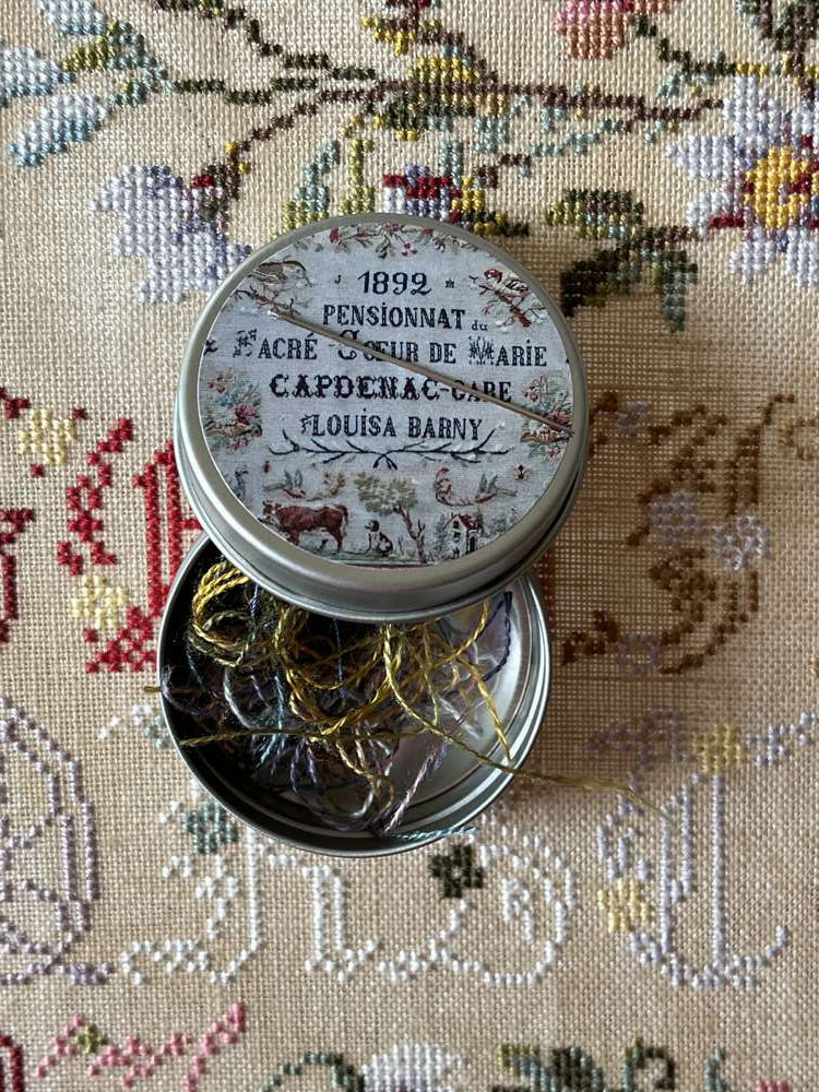 Vintage tin with colorful thread spools, featuring floral design and 1892 label, perfect for craft projects.