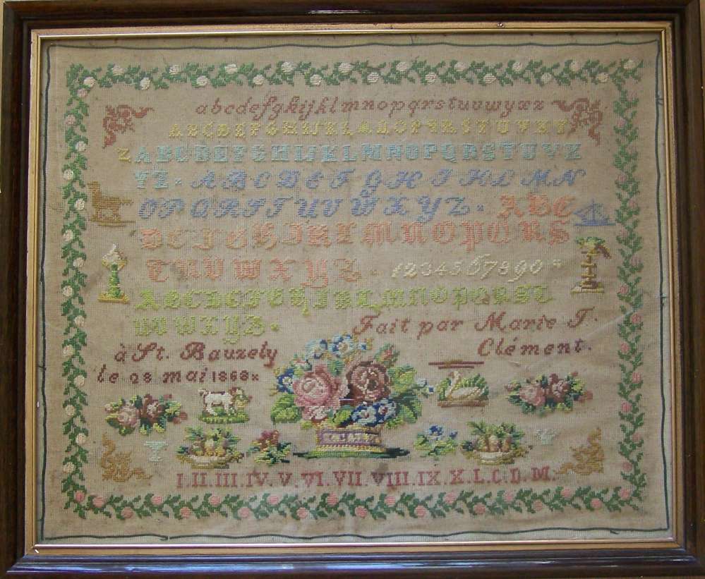Vintage framed embroidery sampler with colorful letters and floral designs, crafted in 1866.