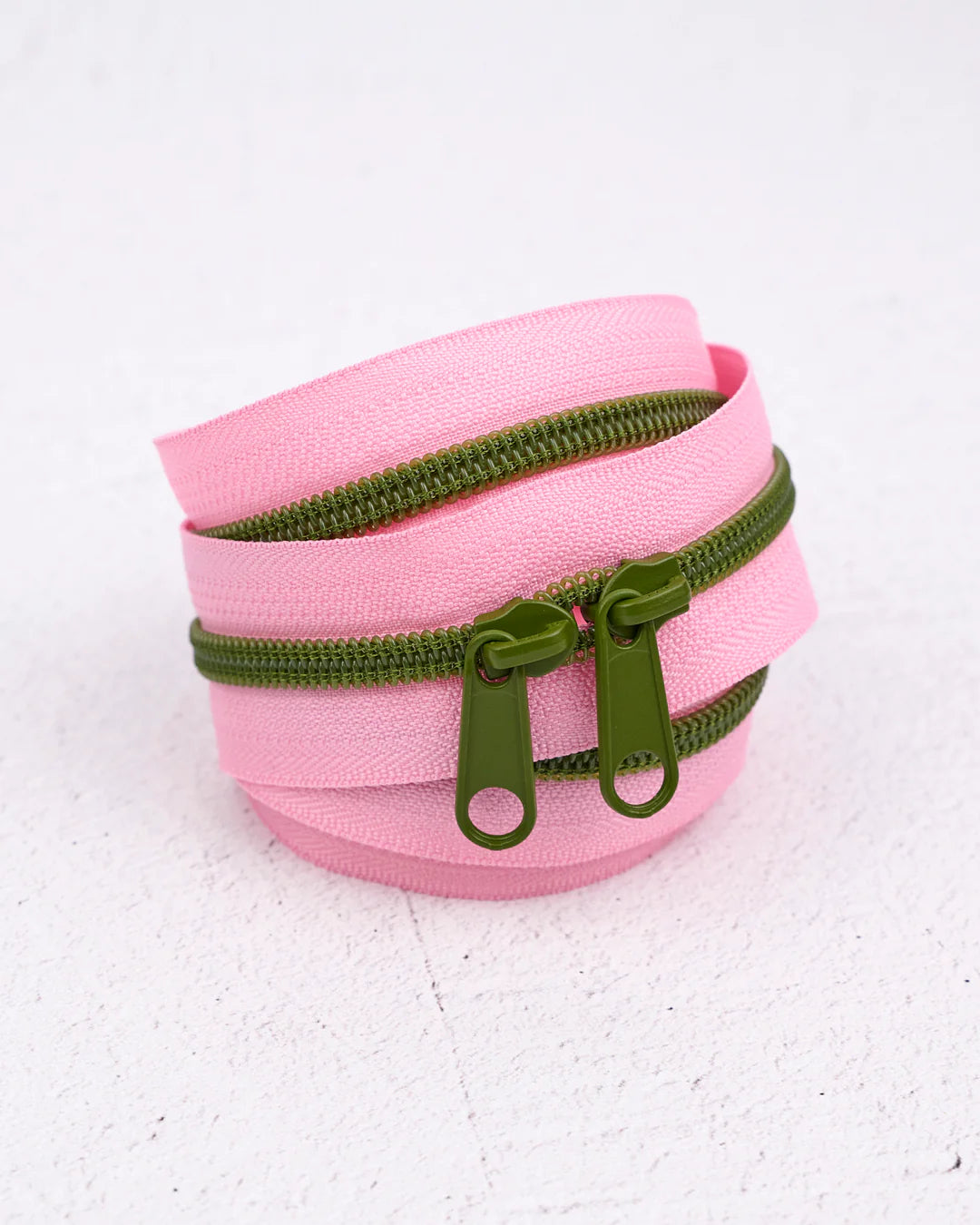 Pink double zipper pouch with green hardware, perfect for organizing small items and accessories.