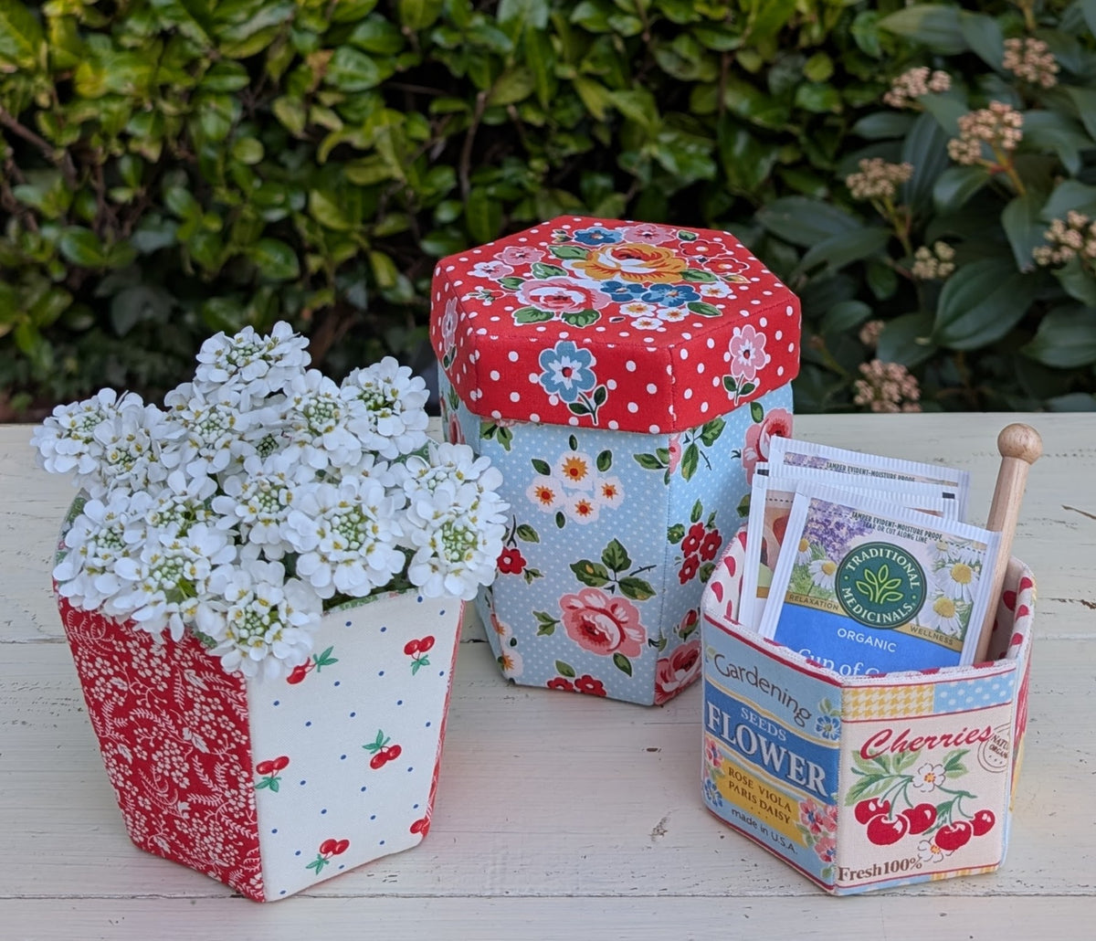 Colorful fabric planters with flowers and seed packets, featuring floral patterns and hexagonal design.