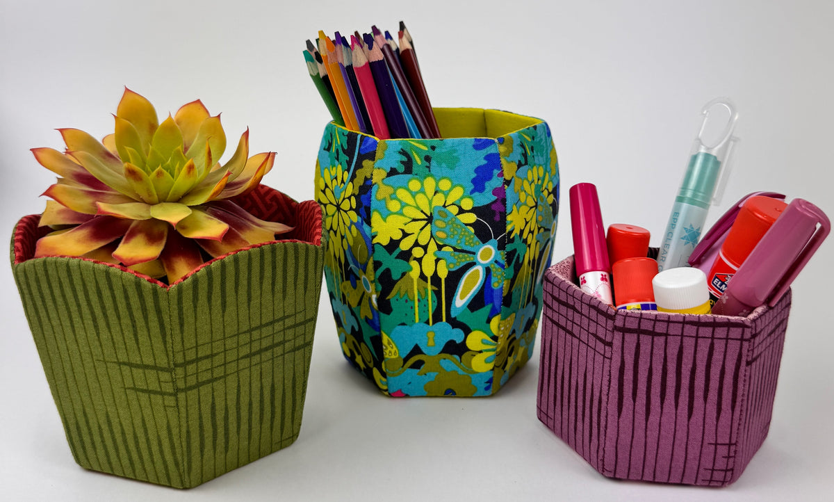 Colorful fabric storage bins in green, blue floral, and pink, perfect for organizing plants and office supplies.