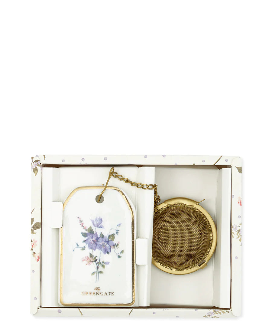Floral tea infuser set featuring a porcelain tag and gold-tone metal strainer in a decorative box.