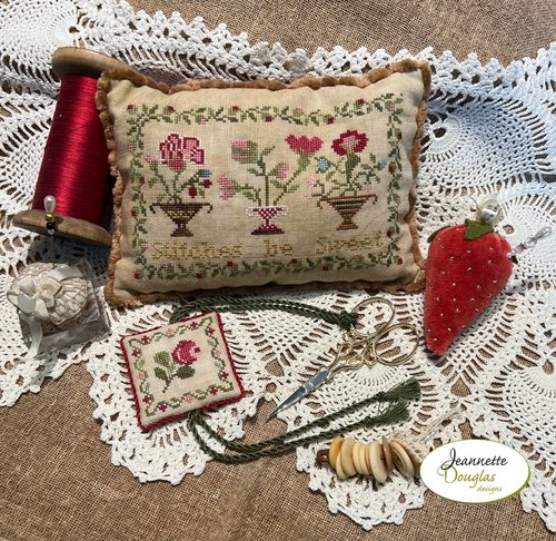 Embroidered floral pillow, cream fabric with colorful flowers, vintage design, ideal for home decor.