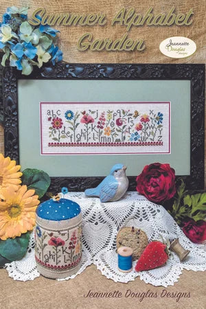 Framed cross-stitch pattern 'Summer Alphabet Garden' featuring colorful flowers, by Jeannette Douglas Designs.