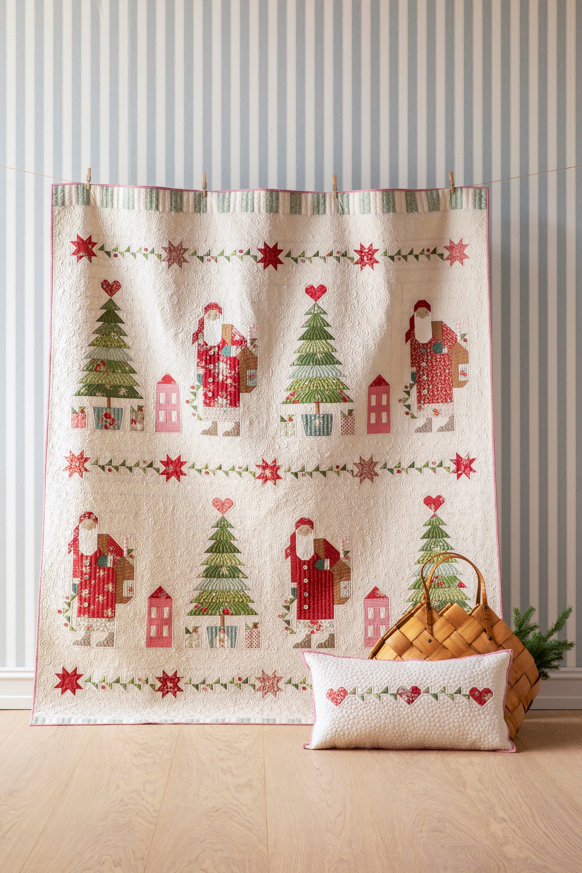 Christmas-themed quilt featuring Santa, trees, and houses in red, green, and cream colors.
