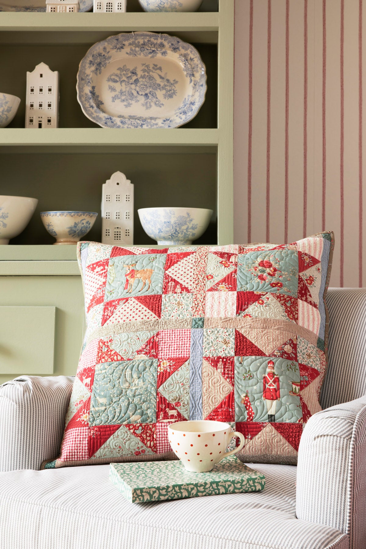 Colorful quilted pillow in red and blue patterns, featuring festive designs, perfect for cozy decor.