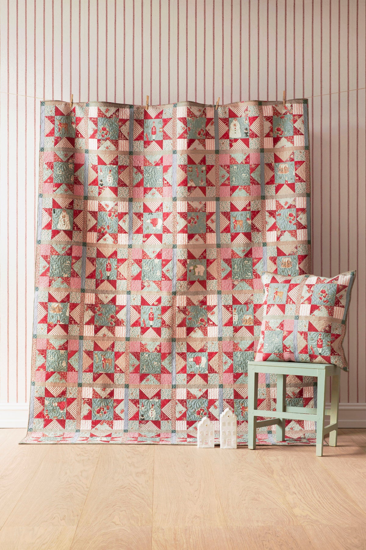 Colorful quilt featuring star patterns in red and blue, complemented by a matching decorative pillow.