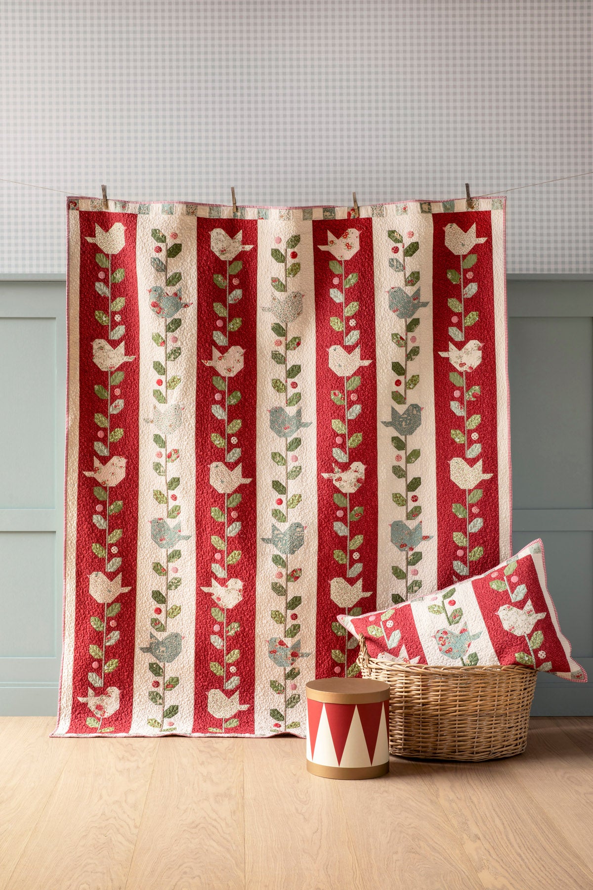 Quilted red and cream throw with floral and bird patterns, perfect for cozy decor.
