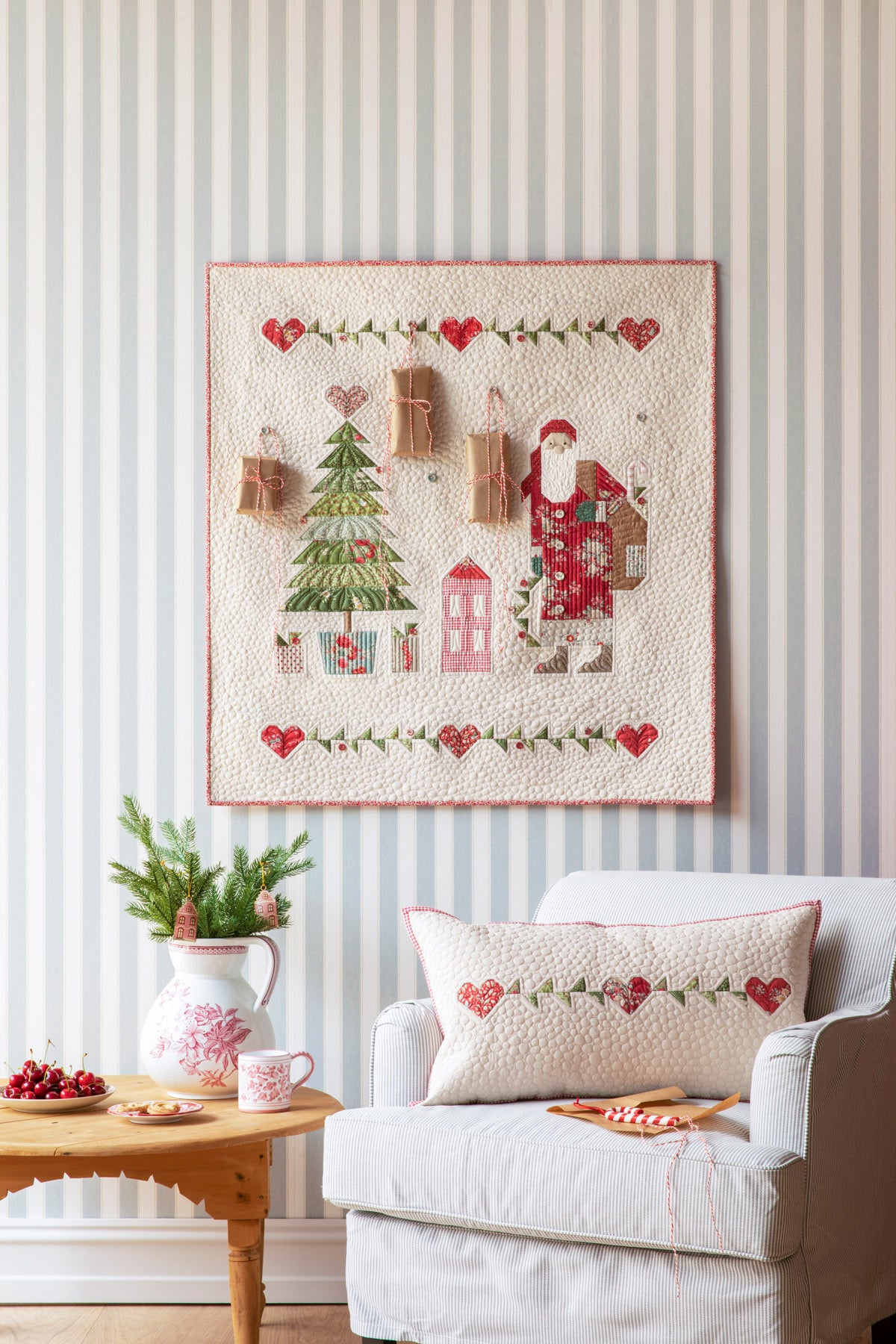 Christmas-themed quilt wall hanging featuring Santa, a tree, and gifts in festive colors.