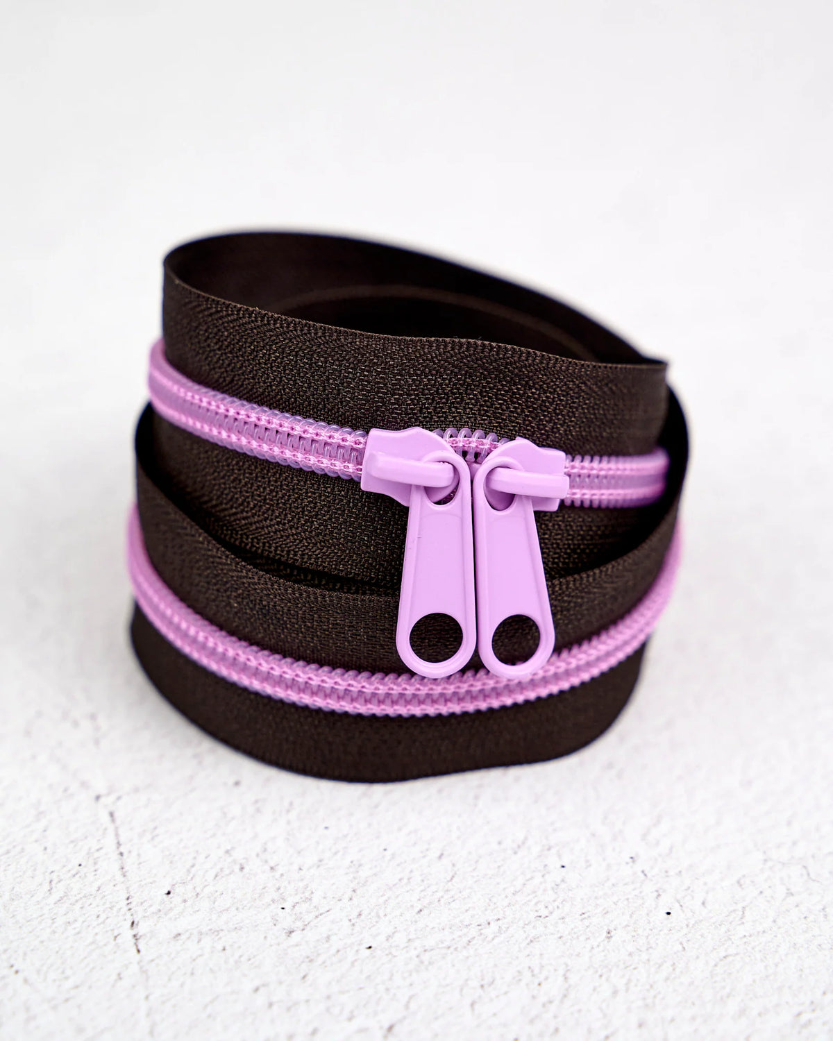 Brown zipper rolls with light pink pulls, perfect for sewing and crafting projects.