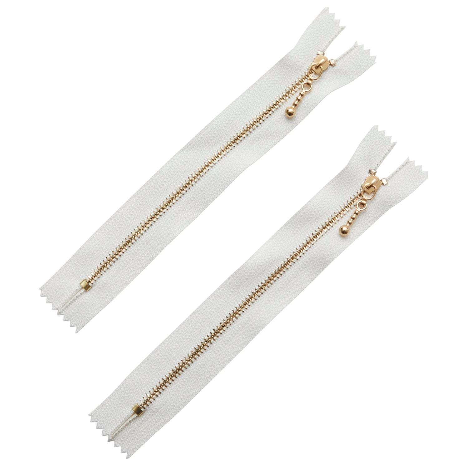 White zippers with gold metal teeth and pull tabs, perfect for clothing and accessories.