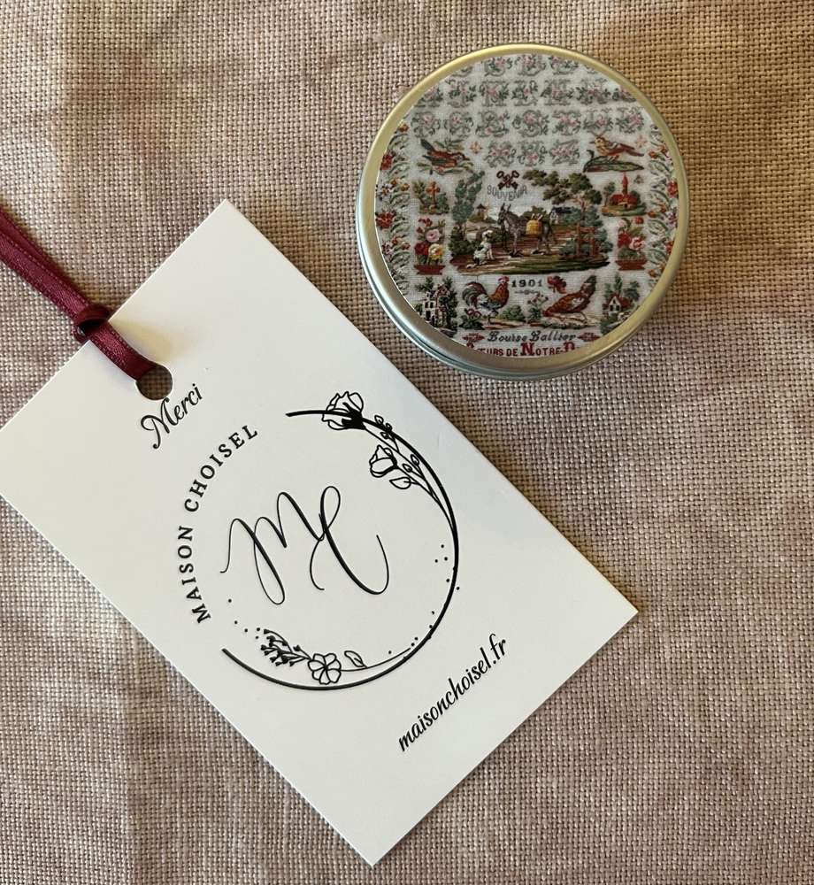 Decorative round tin with vintage floral design, featuring a hang tag from Maison Choisel.