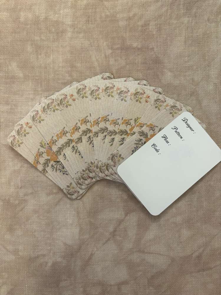 Floral print playing cards featuring vintage design on textured beige background.