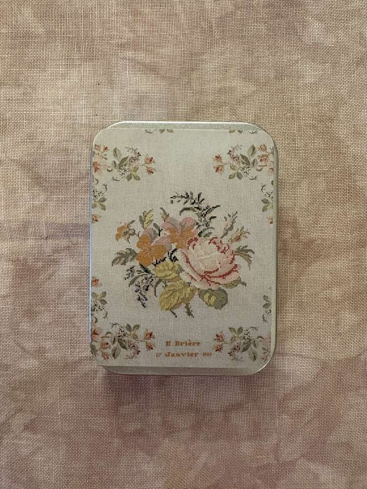 Vintage floral tin box with soft colors, featuring a rose design and elegant lettering on lid.