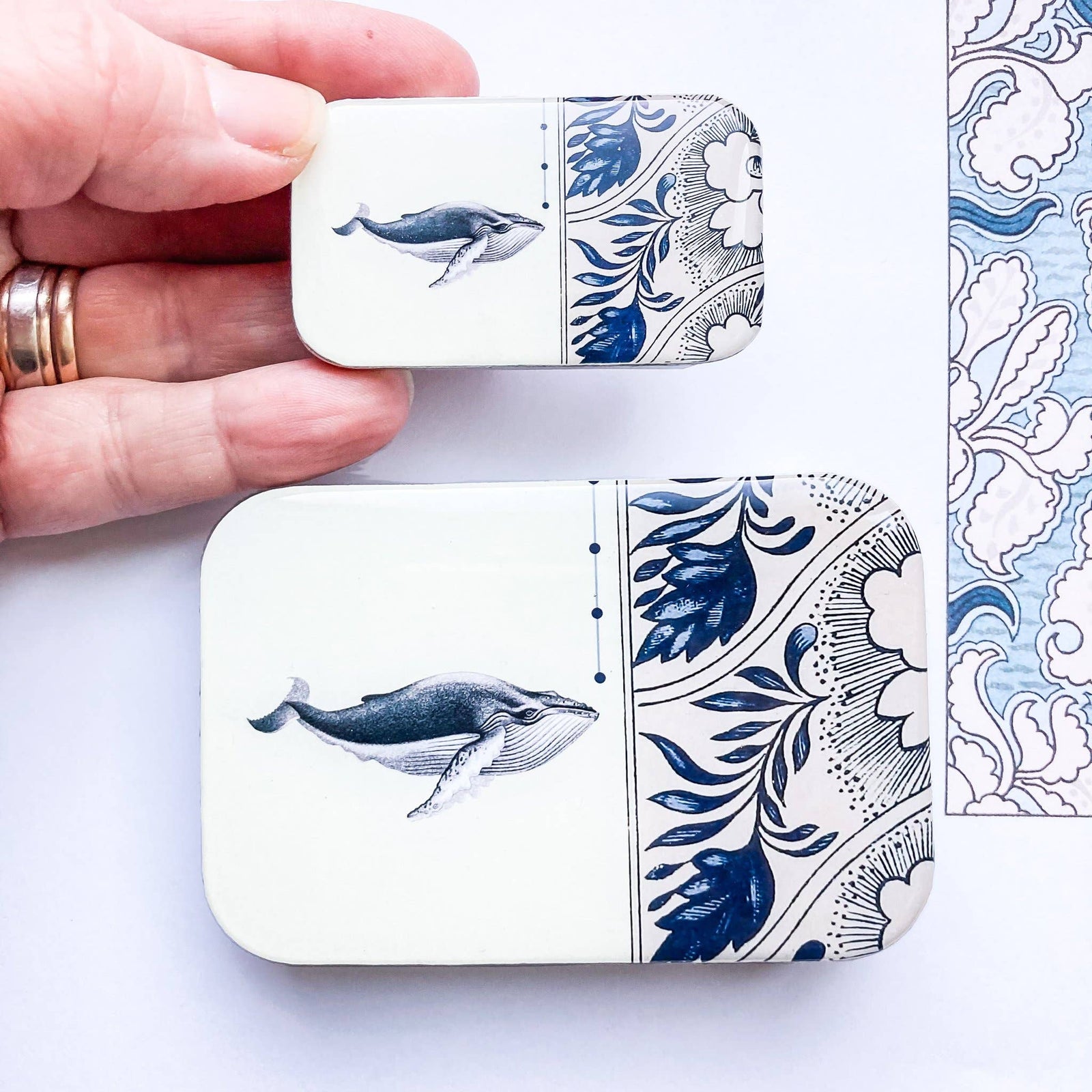 Set of two decorative whale-themed trinket trays in blue and white ceramic, featuring intricate floral designs.
