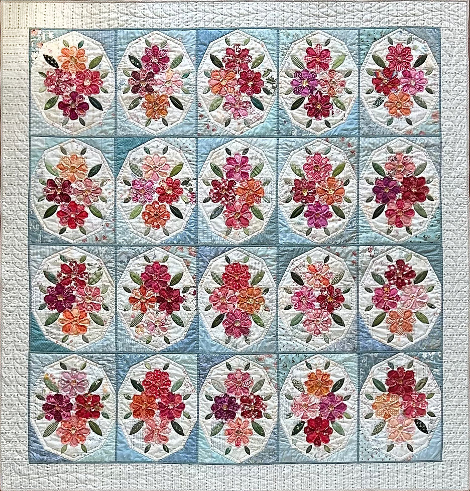 Colorful floral patchwork quilt with vibrant flowers on a light blue background, perfect for home décor.