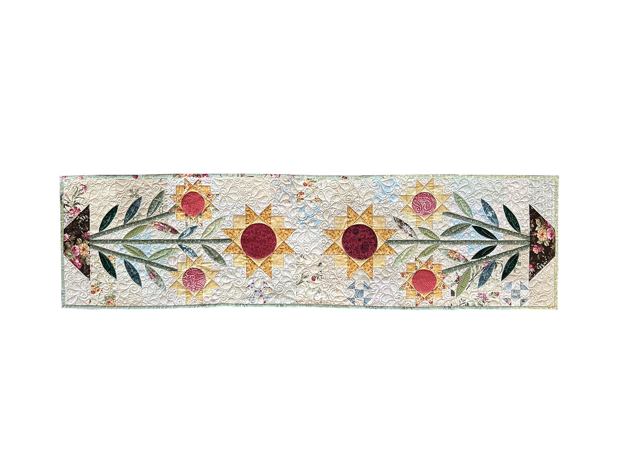Colorful floral quilted table runner with sun and leaf patterns, perfect for home decor.