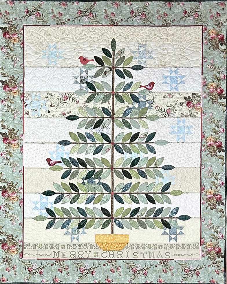 Christmas quilt featuring a decorative tree, leaves, and red birds in shades of green and blue.