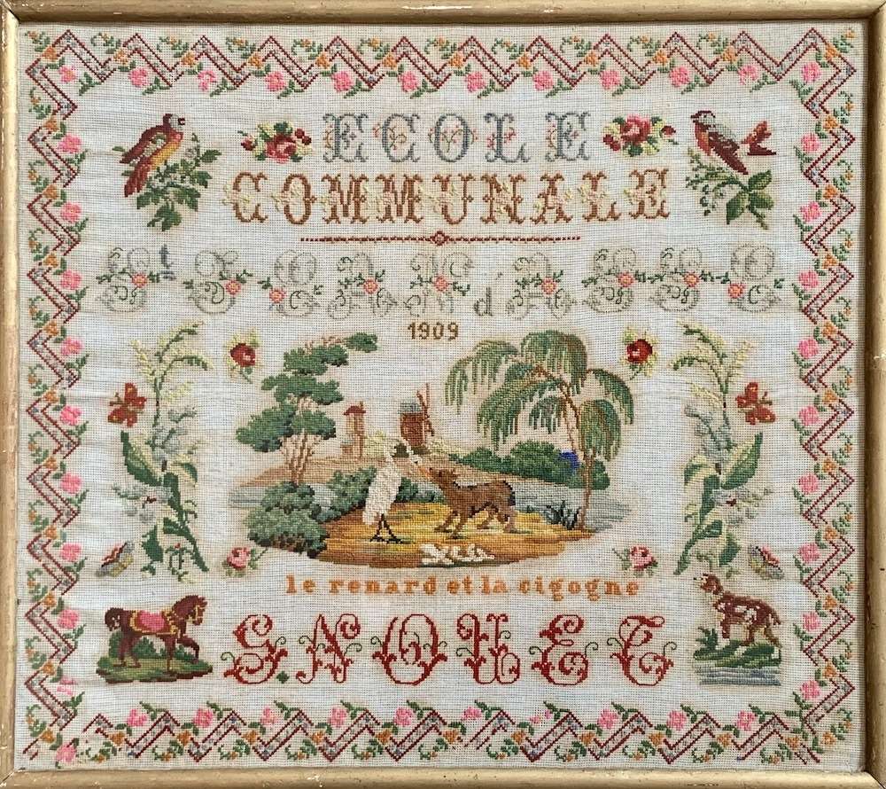 Vintage framed cross-stitch artwork featuring animals, plants, and the year 1909, with intricate floral borders.