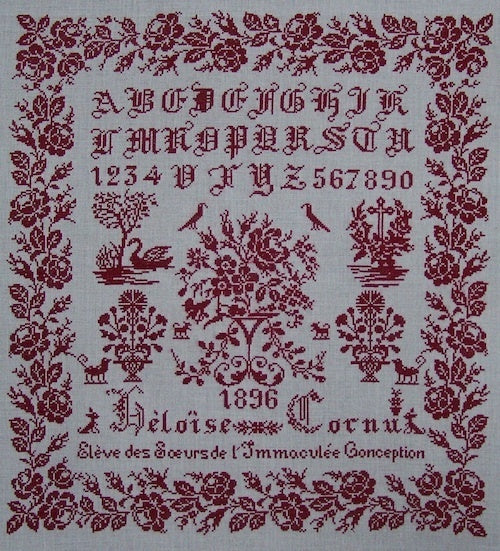 Vintage red and white embroidered sampler featuring alphabets, numbers, and floral motifs, dated 1896.