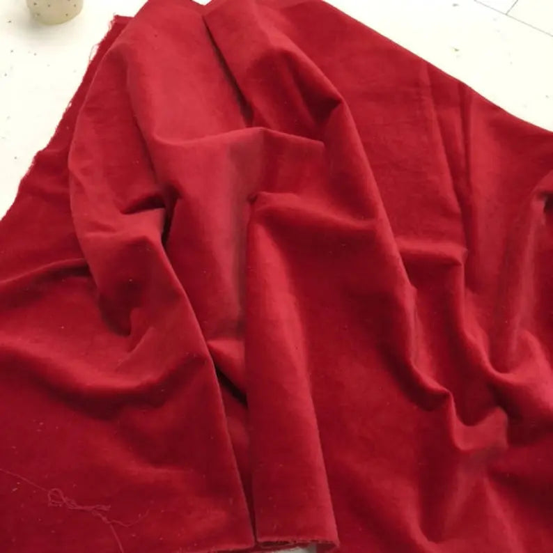 Soft red velvet fabric draped elegantly, perfect for upholstery and craft projects.