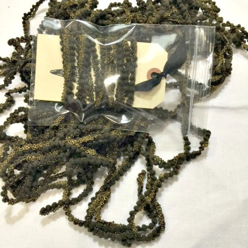 Dark green and gold decorative trim ribbon in a bag, perfect for crafting and sewing projects.