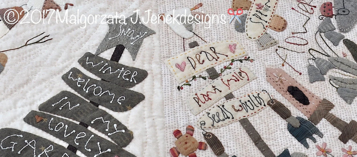 Quilted fabric art featuring sewn garden signs with playful motifs in pastel colors and text.