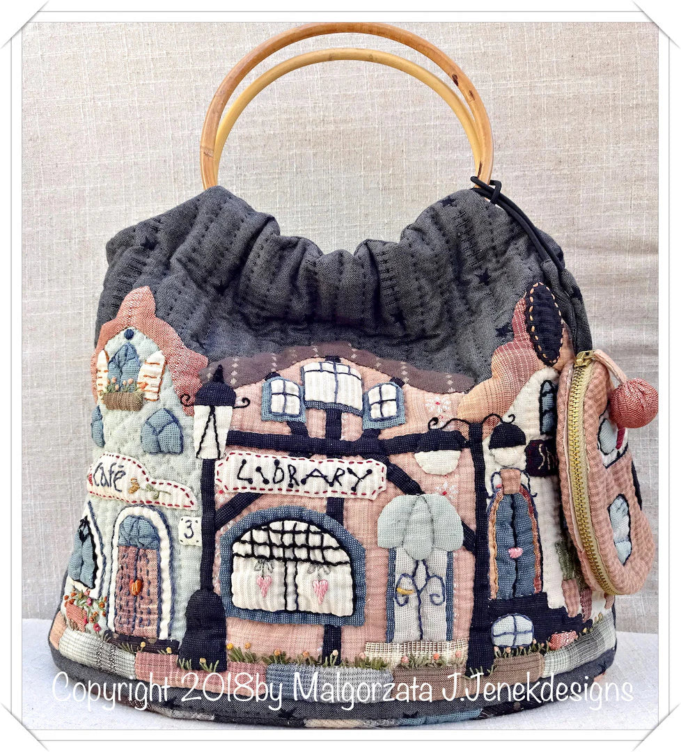 Handcrafted fabric purse with artful library and cafe design, featuring bamboo handles and a drawstring closure.
