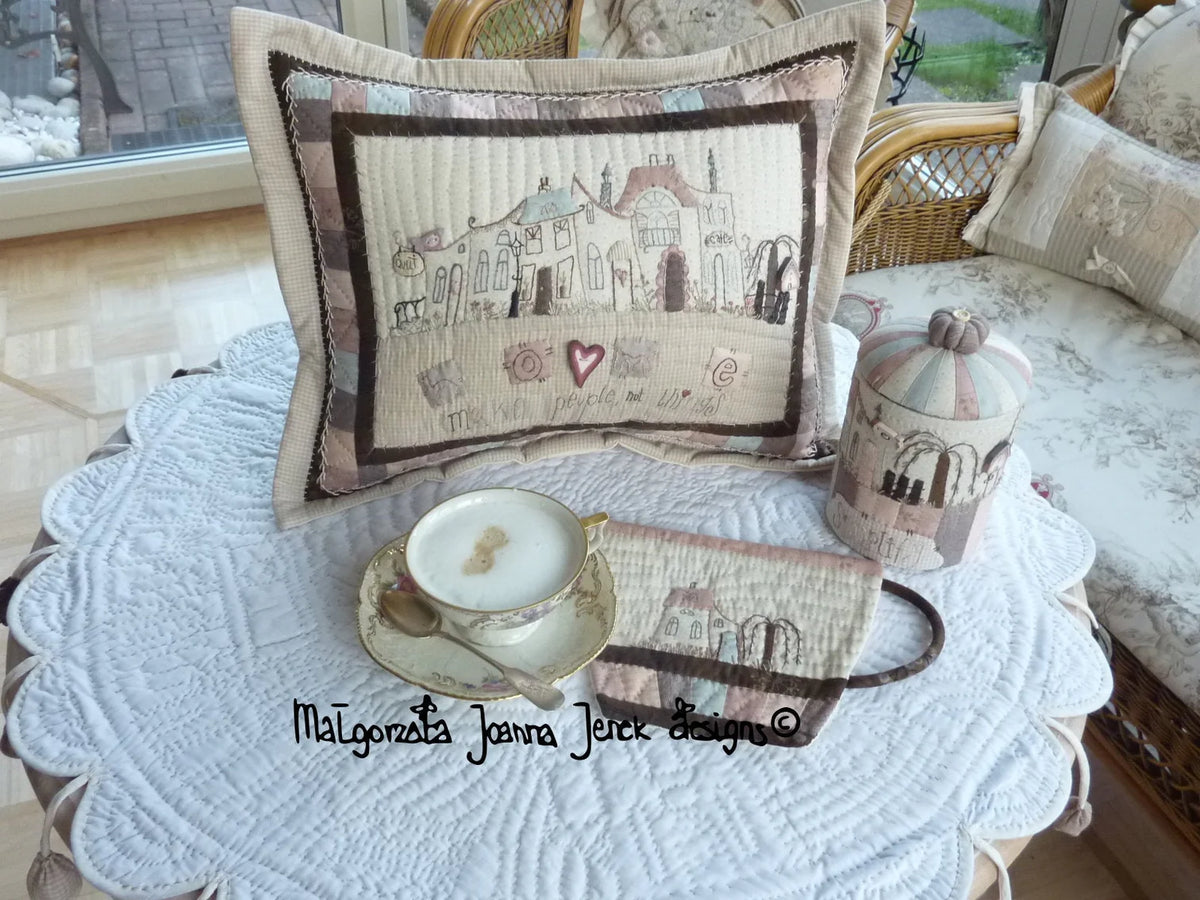 Quilted decorative pillow and container set in pastel colors, featuring charming house designs.